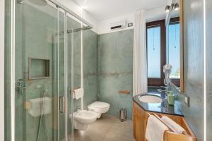 ein Badezimmer mit Toilette und Glasdusche in der Unterkunft Sunshine Apartment in Pimonte + 18 Fotos