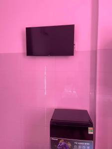 a pink wall with a tv and a box at Khách Sạn Thành Châu 2  +7 photos