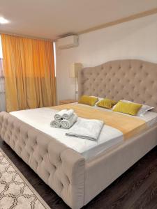 a large bed with towels on it in a bedroom at Djasmines Hotel Astana in Astana