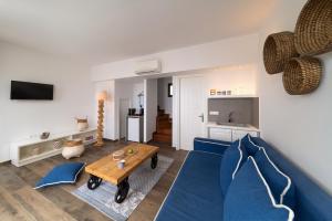 a living room with a blue couch and a table at Lindos Del Mar Suites - Adults Only in Lindos