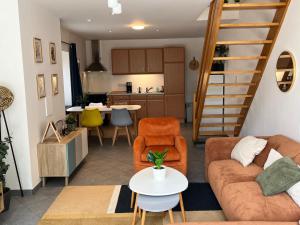 a living room with a couch and chairs and a kitchen at The 8th in Léglise