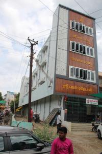 a man standing in front of a building at Srivari Lodge in Arcot