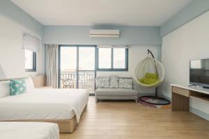 a hotel room with two beds and a television at 澎湖青翠民宿 in Magong
