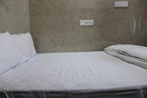 a large white bed in a room with two clocks at Srivari Lodge in Arcot