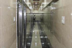 a hallway of a building with a person walking in the distance at Srivari Lodge in Arcot