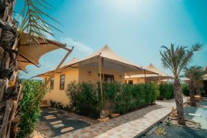 a house with an umbrella in front of it at Chokhi Dhani The Palace Hotel in Jaisalmer