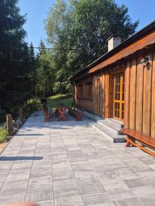 a patio with a cabin with a picnic table and benches at Zátiší na pomezí in Bukovec +13 photos