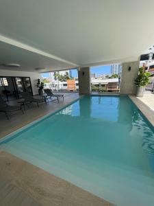 a large blue swimming pool in a building at Furnished two-bedroom apartment DN in Solorín