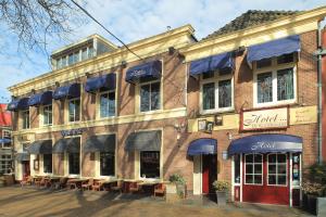 een bakstenen gebouw met tafels en stoelen ervoor bij Hotel de Koophandel in Delft