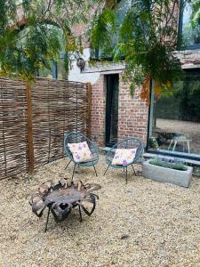 a patio with two chairs and a fire pit at Between hills and home in Trooz