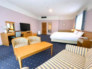 a hotel room with a bed and two chairs at Hotel Floracion Nasu in Nasu