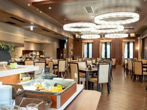 a dining room with tables and chairs and chandeliers at Hotel Floracion Nasu in Nasu