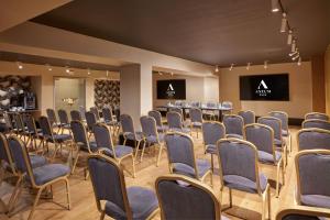 a room with rows of chairs and a screen at Antum Hotel in Benevento