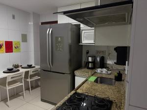 a kitchen with a stainless steel refrigerator and a sink at Ed forte da Praia in Guarapari