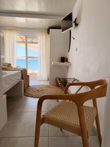 a bedroom with a bed and a chair and a window at Zacharias Seaside Studio Kimolos in Kimolos