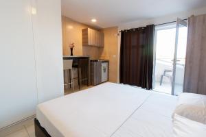een groot wit bed in een kamer met een raam bij Apartments Feniks in Ulcinj