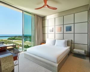 a bedroom with a white bed and a large window at Voyage Kundu in Antalya