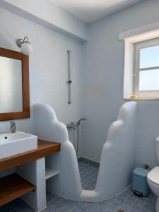 a bathroom with a white sink and a mirror at LA MAISON D'HELENE in Naousa