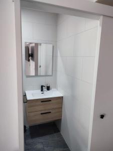 a white bathroom with a sink and a mirror at Apartamento Centro in Rubí