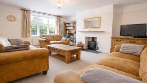a living room with two couches and a tv at Cloudbreak Hot Tub Log Burner Dogs Welcome in Braunton