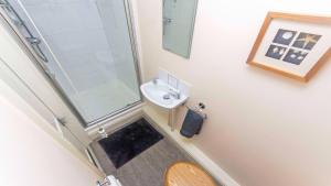 a bathroom with a shower and a sink and a toilet at Cloudbreak Hot Tub Log Burner Dogs Welcome in Braunton +14 photos