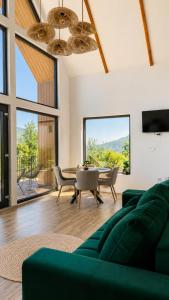 a living room with a green couch and a table at Triovista Chalets in Nehoiu