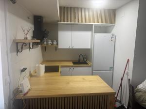a kitchen with a wooden counter and a refrigerator at Apartamento Centro in Rubí