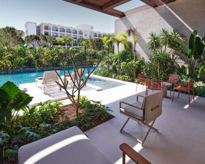 a patio with chairs and a table and a pool at Voyage Kundu in Antalya