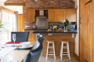 a kitchen with a counter and a table with stools at Blackberry Barn in Wotton-under-Edge