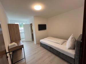 a small bedroom with a bed and a television at Hotel Ruble in Homburg