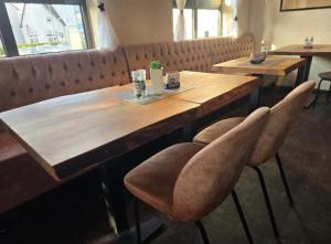 a wooden table in a restaurant with two chairs at Hotel Ruble in Homburg