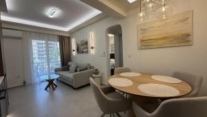 a living room with a table and chairs and a couch at Loutraki Sea Breeze Sunset Apt in Loutraki