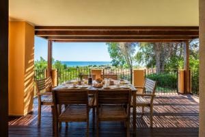 a dining table on a deck with a view of the ocean at Villa Panorama Private Pool Costa Rei in Monte Nai