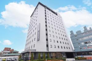 a tall white building with a lot of windows at Dormy Inn Express Kakegawa in Kakegawa