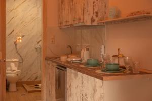 a kitchen with a counter top with green dishes on it at vranas hotel in Skala Sotiros +78 photos