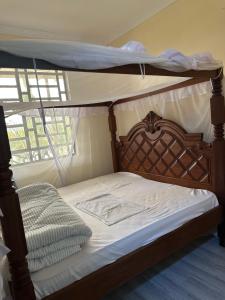 a bed with a canopy bed with white sheets at Bella Pollito in Nairobi +44 photos