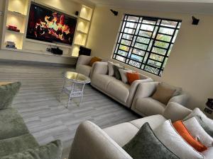 a large living room with couches and a tv at Bella Pollito in Nairobi