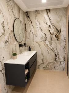 a bathroom with a sink and a mirror on a stone wall at Our long Vacation in Quesada in Ciudad Quesada +11 photos