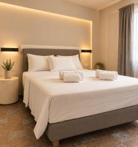 a bedroom with a large white bed with two pillows at Noéma Mani Boutique Residences in Gythio