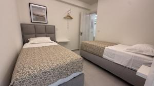 a bedroom with two beds in a room at Loutraki Sea Breeze Sunset Apt in Loutraki