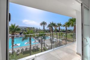 a view of the pool and palm trees from a balcony at The View Bouznika in Bouznika
