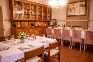 a dining room with a long table with chairs and a chandelier at Bakenskraal Ostrich Palace in Oudtshoorn