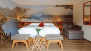 a bedroom with a bed and a couch and a table at Boutiquehotel Acherl in Achenkirch