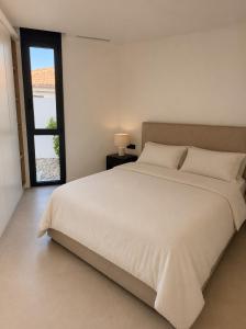 a bedroom with a large white bed and a window at Our long Vacation in Quesada in Ciudad Quesada