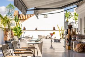 a patio with chairs and tables and a drink at Intelier Casa de Indias in Seville +77 photos