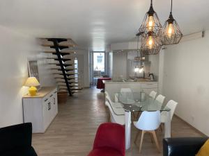 a dining room and kitchen with a glass table and chairs at Gite de groupe lacs et forêt du jura - SPA et Sauna Privatif - Orgelet in Orgelet