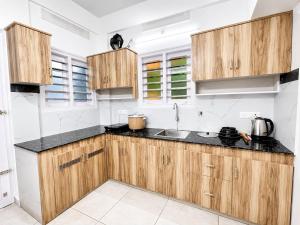 a kitchen with wooden cabinets and black counter tops at Aura Suites Chernallur in Ernakulam
