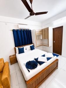a bedroom with a large bed with a blue curtain at Aura Suites Chernallur in Ernakulam