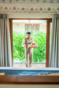 a man is holding a tray of food at Chokhi Dhani The Palace Hotel in Jaisalmer +110 photos