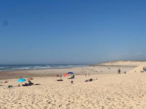 a group of people on a beach with umbrellas at Cozy apartment in Moliets-et-Maa